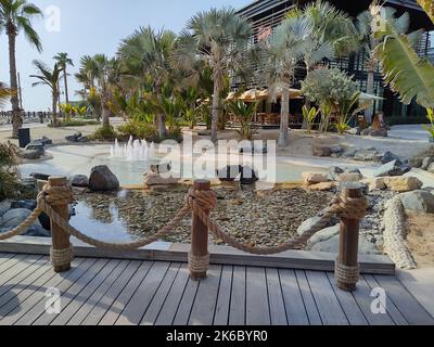Un passaggio panoramico contro la fontana e gli alberi a la Mer, Dubai Foto Stock