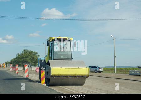 I rulli della strada che lavorano sulla nuova costruzione stradale, il compattatore che lavora sull'asfalto Foto Stock