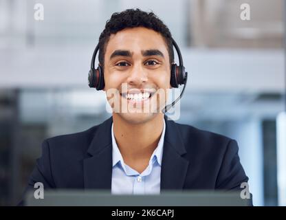 IM proprio qui al vostro servizio. Ritratto di un giovane operatore del call center che lavora in ufficio. Foto Stock