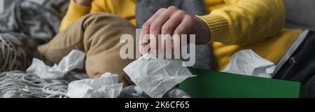 vista parziale dell'uomo malato che si trova vicino a tovaglioli di carta stropicciati, banner, immagine di scorta Foto Stock