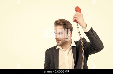 Il responsabile serio della chiamata telefonica tiene il ricevitore vecchio-stile del telefono vintage, la comunicazione telefonica Foto Stock