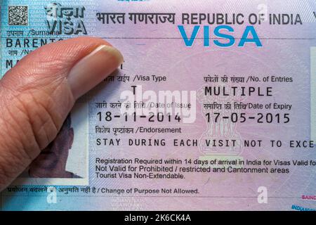 Mano che tiene il passaporto aperto con il visto della Repubblica dell'India in passaporto britannico Foto Stock