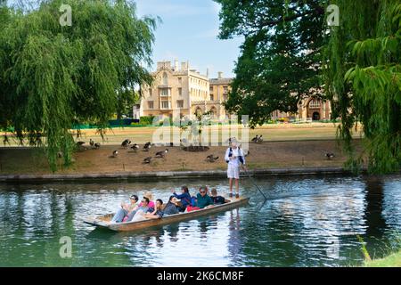 I turisti sul fiume Cam in un tour panoramico in barca a Cambridge in Inghilterra, con il St Johns College sullo sfondo Foto Stock