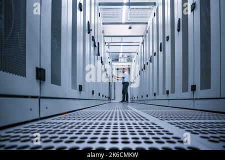 13 ottobre 2022, Sassonia, Taucha: Michael Freitag, Group Manager Data Center Management, controlla i cabinet dei server nel nuovo data center di Datacenter Leipzig. Lo stesso giorno, il primo nodo Internet regionale per gli stati tedeschi di Brandeburgo, Sassonia, Sassonia-Anhalt e Turingia è andato online qui. DE-CIX Leipzig fa parte del più grande ecosistema di interconnessione neutrale del mondo, collegando oltre 2.500 operatori di rete, provider di servizi Internet, provider di contenuti e reti aziendali di oltre 100 paesi. Il nodo, gestito dall'operatore di rete in fibra ottica Envia Tel, è locate Foto Stock