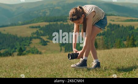 Giovane fotografo che ha girato un bel film. Ragazza che genera il soddisfare in movimento, risultati di wathing e sensibilità felice, spendendo il tempo libero all'aperto Foto Stock