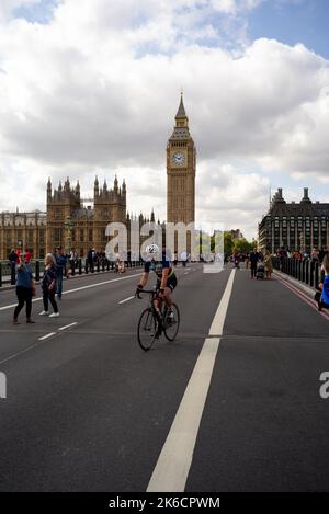 Un ciclista solitario sul Westminster Bridge scorre nel mezzo della strada dopo il ponte è vicino al traffico come parte della cerimonia del Queens Lying in state. Foto Stock