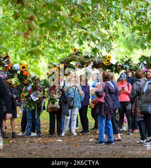 Un tributo floreale di Sun Flowers avvolto intorno ad un ramo di albero nel Green Park London UK ammirato dai luratori che frequentano il parco per deporre i fiori. Foto Stock