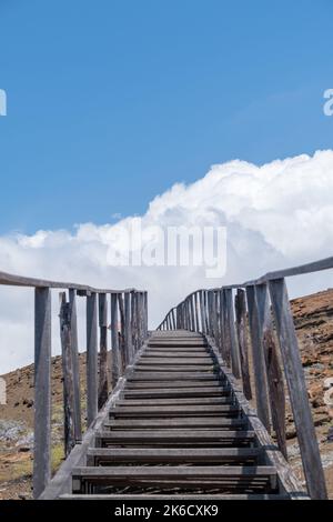 Uno scatto verticale di una scala che conduce alle montagne che toccano il cielo nelle isole Galapagos, Ecuador Foto Stock