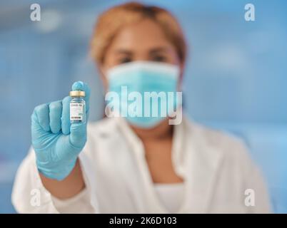 Siete pronti per il prossimo passo. Una giovane lavoratrice di laboratorio femminile in possesso di una fiala di vaccino. Foto Stock