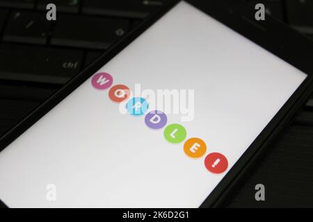 Berlino, Germania - 10.13.2022 Uno smartphone con il logo del famoso gioco di parole Wordle close-up si trova su una tastiera del computer. Foto Stock