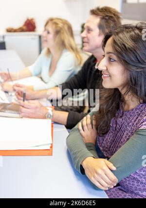 Educazione degli adulti: Apprendimento candiato. Gli studenti maturi si sono concentrati sulla presentazione degli insegnanti in classe. Da una serie di immagini correlate sul soggetto. Foto Stock