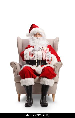 Babbo natale seduto in poltrona e mangiare popcorn isolato su sfondo bianco Foto Stock