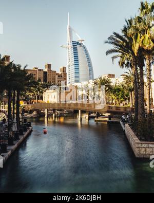 Uno scatto verticale del Burj al Arab Hotel con un fiume in primo piano Foto Stock