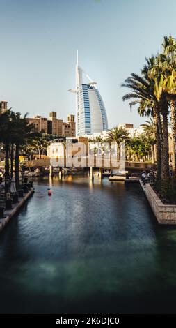 Uno scatto verticale del Burj al Arab Hotel con un fiume in primo piano Foto Stock