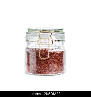 Vaso di vetro di quinoa rossa isolato su sfondo bianco. Foto Stock