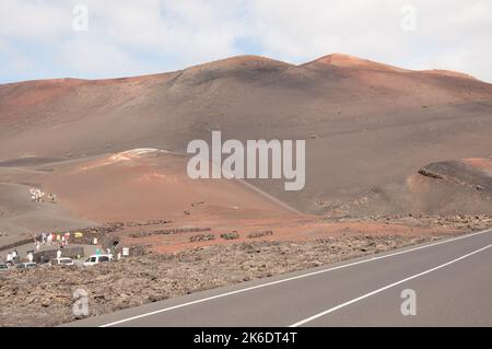 Gite in cammello tra i vulcani, Parco Nazionale di Timanfaya, Lanzarote, Isole Canarie. Diverse centinaia di cammelli sono conservati nella zona di Timanfaya e utilizzati t. Foto Stock