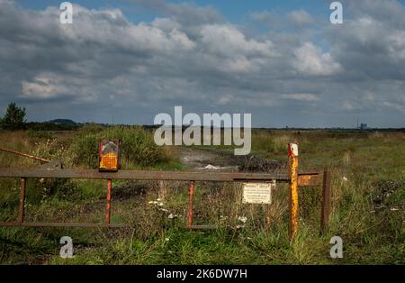 Resti di una vecchia traversata ferroviaria per il trasporto di torba attraverso Bord na Móna. In lontananza la centrale elettrica di Edenderry. Foto Stock