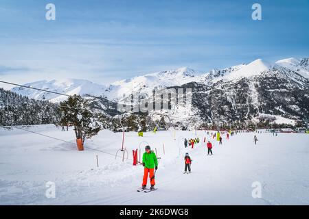 People, adults and kids, skiers and snowboarders going up on drag lift. Ski winter holidays in Andorra, El Tarter, Pyrenees Mountains, Grandvalira Foto Stock