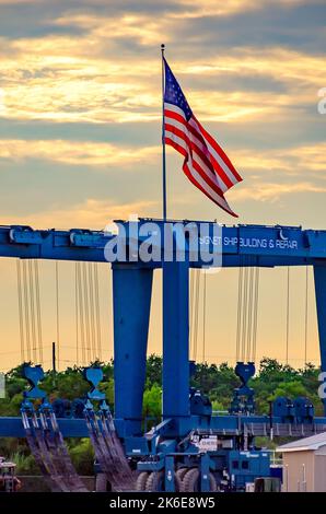 Una bandiera americana vola sopra un argano da 600 tonnellate Marine Travelift presso Signet Shipbuilding & Repair, un cantiere navale di proprietà di Signet Maritime Corporation. Foto Stock