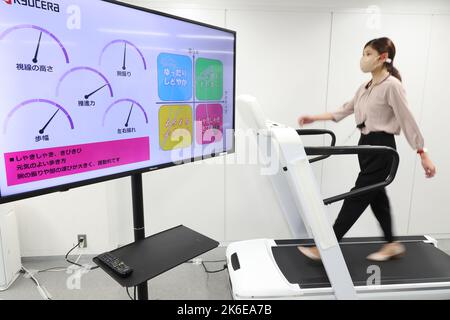 Tokyo, Giappone. 13th Ott 2022. Il gigante giapponese dell'elettronica Kyocera, dipendente, cammina su un tapis roulant per dimostrare il sistema di rilevamento e coaching dell'azienda con tre sensori indossabili di auricolari, braccialetto e caviglia a Tokyo giovedì 13 ottobre 2022. Il sistema di rilevamento a piedi misura la postura con sensori minuscoli e fornisce diagnosi e formazione in tempo reale tramite un auricolare. Credit: Yoshio Tsunoda/AFLO/Alamy Live News Foto Stock