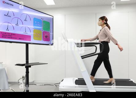 Tokyo, Giappone. 13th Ott 2022. Il gigante giapponese dell'elettronica Kyocera, dipendente, cammina su un tapis roulant per dimostrare il sistema di rilevamento e coaching dell'azienda con tre sensori indossabili di auricolari, braccialetto e caviglia a Tokyo giovedì 13 ottobre 2022. Il sistema di rilevamento a piedi misura la postura con sensori minuscoli e fornisce diagnosi e formazione in tempo reale tramite un auricolare. Credit: Yoshio Tsunoda/AFLO/Alamy Live News Foto Stock