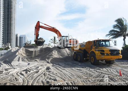 Un escavatore siede sulla cima di un grande mucchio di sabbia della spiaggia e carica la sabbia su un camion di scarico all'Indian Beach Park a Miami, Fl., Il corpo dell'esercito degli Stati Uniti continua a lavorare al progetto di Miami Beach Renourishment che distribuisce la disposizione della sabbia all'estremità meridionale dell'Indian Beach Park e di Allison Beach. (Foto USACE di Mark Rankin) Foto Stock