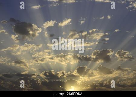 Magnifico tramonto sul cielo. Sole coperto da nuvole pittoresche con splendidi raggi di sole nel cielo. Astratto sfondo naturale blu, sci tranquillo Foto Stock