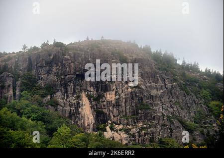 Acadia National Park, Maine, USA. La persistente nebbia tocca la sommità di una cupola di granito, una delle caratteristiche che definiscono l'Acadia National Park. Foto Stock