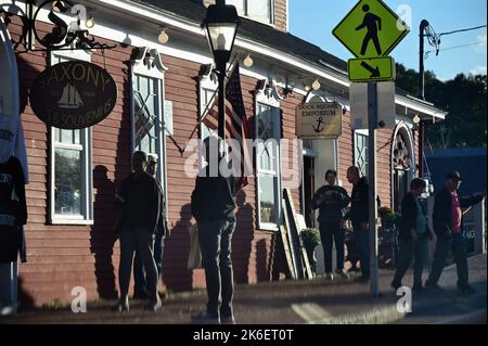 Kennebunkport, Maine, Stati Uniti. I visitatori e i turisti, alla luce tarda di una giornata autunnale, si riuniscono all'esterno di un esclusivo negozio di Dock Square. Foto Stock