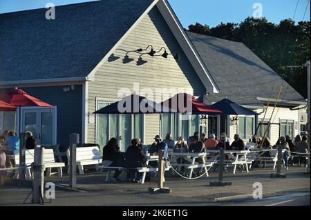 Kennebunkport, Maine, Stati Uniti. I visitatori, alla luce tarda di una giornata autunnale, potranno cenare all'aperto in un ristorante locale nell'elegante Dock Square. Foto Stock