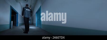 Guardia di sicurezza con torcia di notte in magazzino Foto Stock