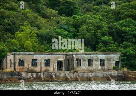 Edifici abbandonati di un'ex fattoria di ostriche di perle a lo fu Wat, una baia appartata sulla riva settentrionale del canale di Tolo, New Territories, Hong Kong Foto Stock