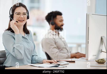 Contattateci, call center e donna felice nelle vendite assicurative parlare, aiutare e lavorare presso un banco di assistenza clienti. Smile, telecomunicazioni e telemarketing Foto Stock