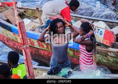 Costa del Capo, Ghana - 05 aprile 2022: Gente africana locale del Ghana che nuotano ed avendo divertimento nell'acqua calda dell'Oceano Atlantico Foto Stock