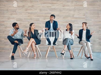 Se questo isnt favoritism, non so che cosa è. Foto a tutta lunghezza di un bel giovane uomo d'affari seduto con i suoi colleghi mentre è stato scelto Foto Stock