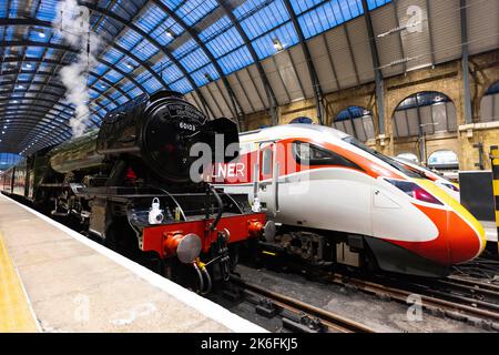 SOLO USO EDITORIALE le opinioni generali del Flying Scotsman accanto al treno Azuma riflettono i treni passati e presenti della London North Eastern Railway (LNER) alla King's Cross Station, Londra. Data immagine: Venerdì 14 ottobre 2022. Foto Stock