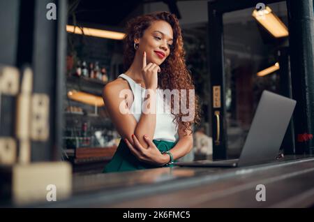 Donna, computer portatile e pensiero in caffetteria, ristorante o caffè brasiliano per il lavoro a distanza, la scrittura di blog di moda o idee ebook. Sorriso felice, studente o. Foto Stock