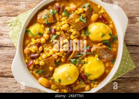 Primo piano del piatto principale di Hamin Cholent tradizionale ebraico per il pasto di Shabbat, carne di manzo cotta lentamente con patate, fagioli e uova di colore marrone primo piano nella padella Foto Stock