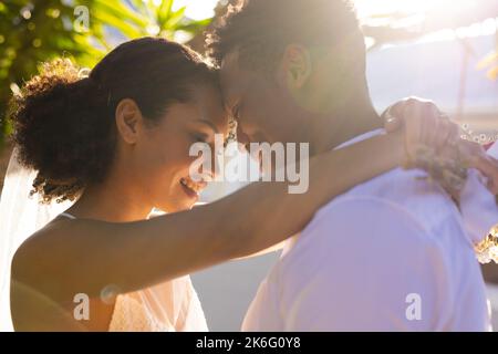 Felice coppia afroamericana sposarsi, abbracciarsi durante il giorno del matrimonio Foto Stock