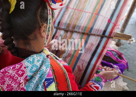 Cusco, Perù - 1 luglio, 2022: Una signora di Quechua tesse tessuti andini tradizionali utilizzando lana alpaca Foto Stock