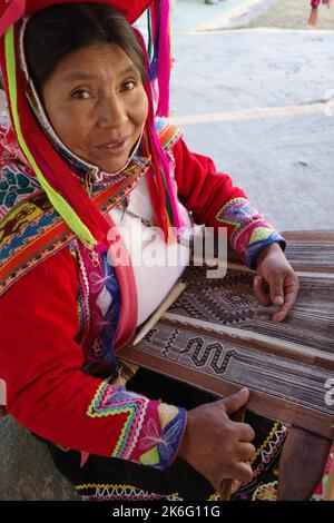 Cusco, Perù - 1 luglio, 2022: Una signora di Quechua tesse tessuti andini tradizionali utilizzando lana alpaca Foto Stock