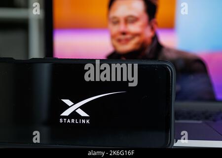 Kaunas, Lituania - 14 ottobre 2022: Il logo Starlink sullo schermo e Elon Musk sullo sfondo Foto Stock
