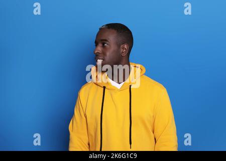 Allegro African American Guy sorridente su sfondo blu. Studio Shot of Happy Self-Confident Black Millennial Man che esprime emozioni positive Foto Stock