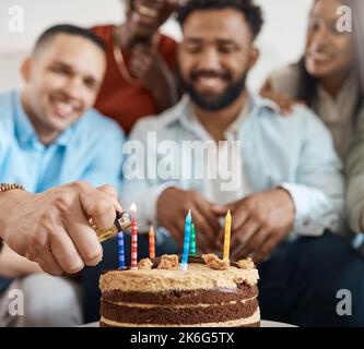 Accendendo le sue candele. un giovane che festeggia il suo compleanno con gli amici a casa. Foto Stock