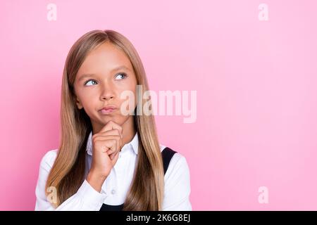 Primo piano foto di giovane divertente bella faccia girlish poco schoolkid signora tocco mento pointed labbra sguardo vuoto prova spazio isolato sul colore rosa Foto Stock