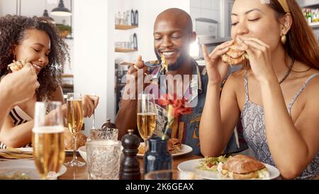Che hamburger succoso. un gruppo di giovani amici che gustano un pasto insieme in un ristorante. Foto Stock