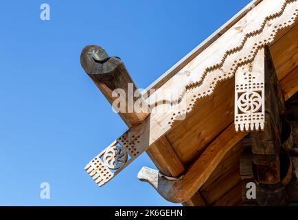 Decorazioni tradizionali in legno intagliate sul tetto di una casa in legno Foto Stock