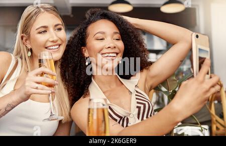 Prenderci un po' di tempo solo per noi. due amici che scattano selfie insieme in un bar. Foto Stock