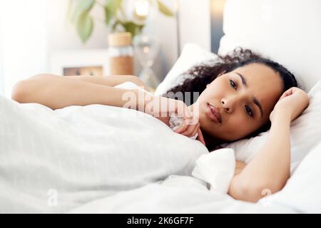 Riposando la malattia via. una giovane donna che riposa ammalata a letto a casa. Foto Stock