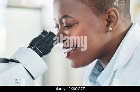 Lavorare su un altro esperimento controllato. una giovane donna che usa un microscopio in un laboratorio. Foto Stock